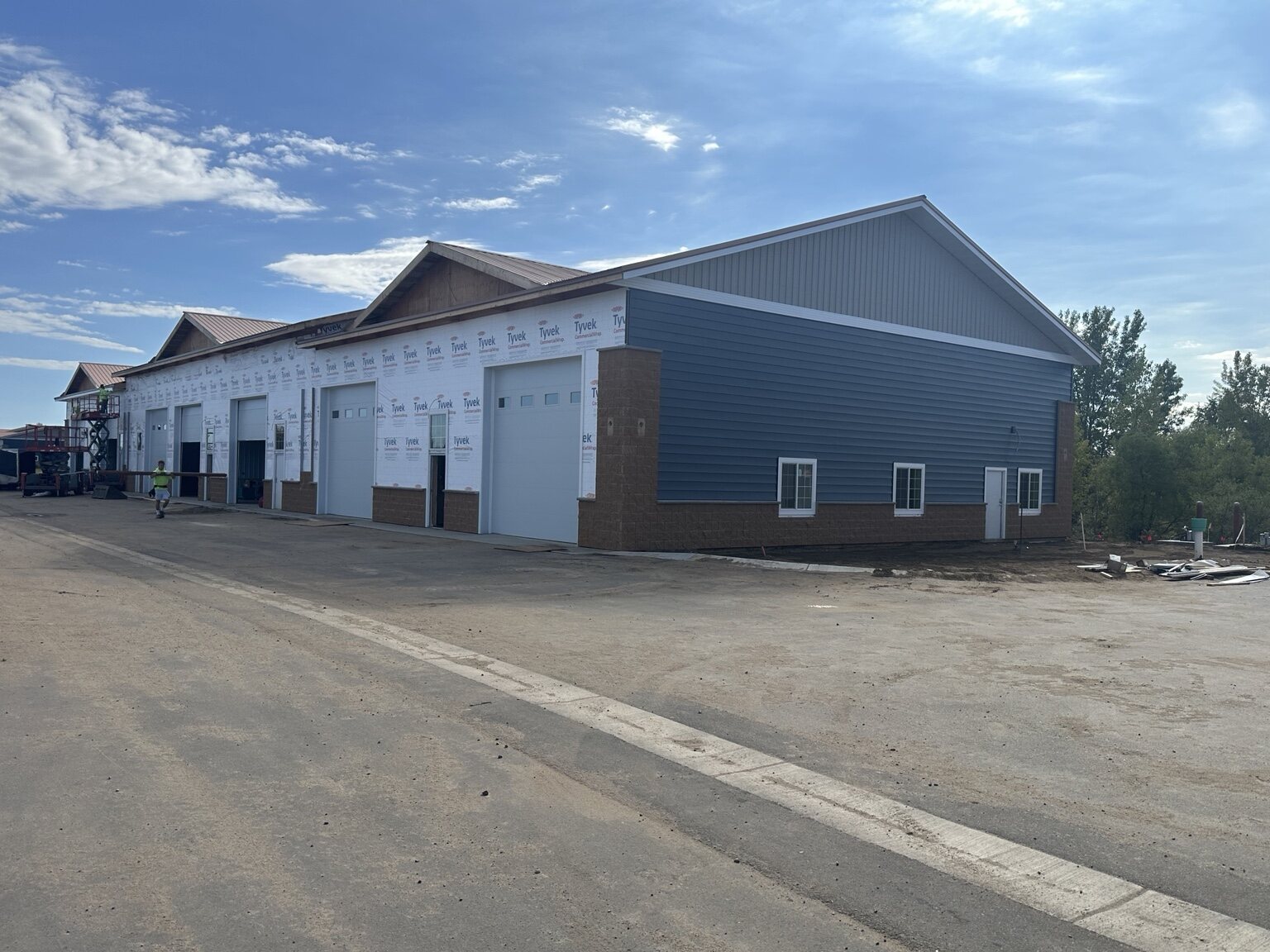 Building 3 exterior with blue-gray siding installation underway