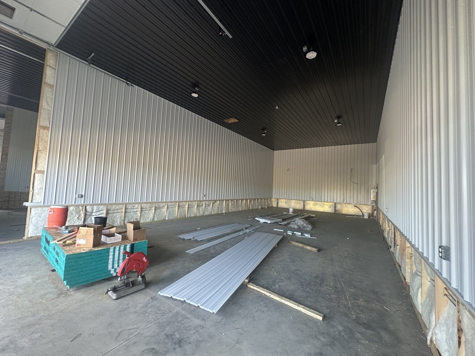 Interior car condo unit under construction with metal wall and ceiling panels